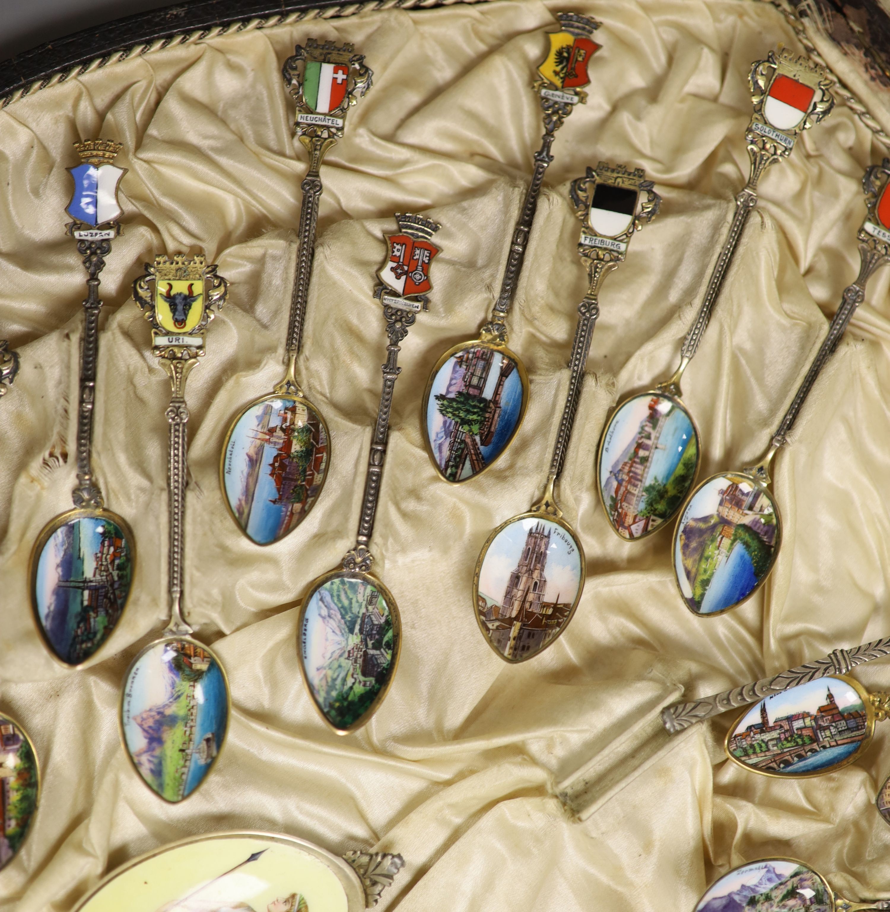 A set of 22 Swiss 800 silver and enamel souvenir spoons, each representative of a Canton, cased, with a larger spoon.